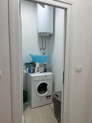 a laundry room with a washing machine and a cabinet at Villa Seventh Heaven in Sutomore