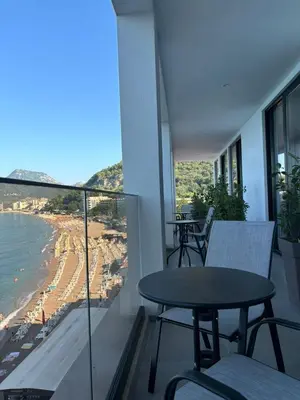 a balcony with a table and chairs and a view of the beach at Hotel Sutomore in Sutomore