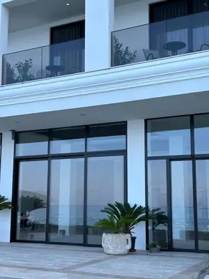 a building with large windows and a potted plant at Hotel Sutomore in Sutomore