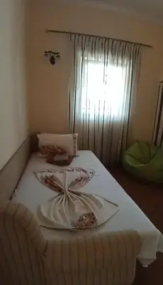 a white bed with a plate on top of it at Villa Delfin 1-2-3-4 in Bar