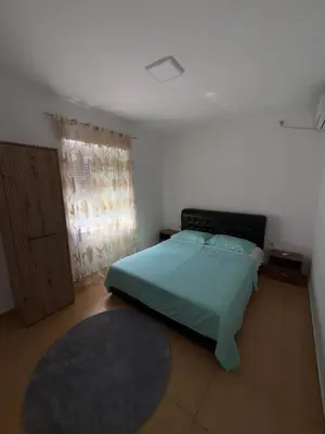 a bedroom with a green bed and a window at Apartments Lazo in Ulcinj
