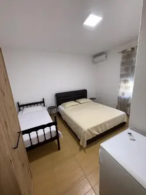 a bedroom with two beds and a refrigerator at Apartments Lazo in Ulcinj