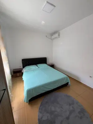 a bedroom with a bed with a green comforter at Apartments Lazo in Ulcinj