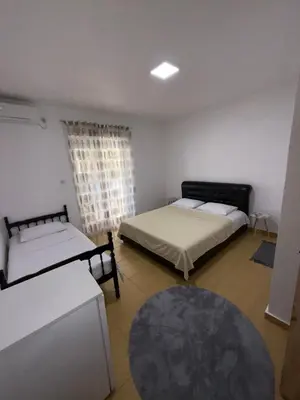 a room with two beds and a rug at Apartments Lazo in Ulcinj