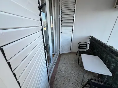 a small balcony with a table and a bench at Guest House Plima 2 in Budva
