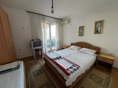 a bedroom with a large bed and a tv at Guest House Plima 2 in Budva