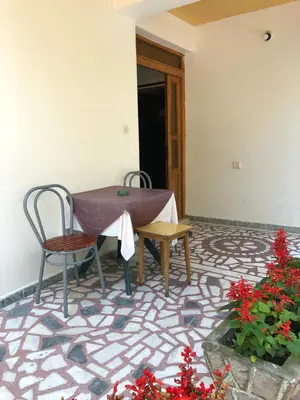 a table and chairs in a room with flowers at Guest House Plima 2 in Budva