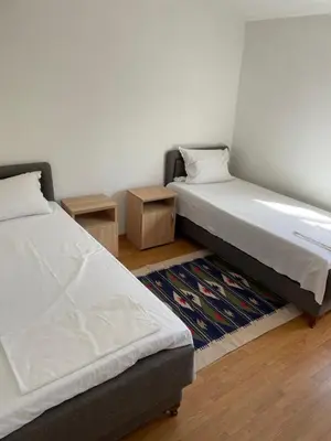 a bedroom with two beds and a rug and two tables at Grapefruit Home Apartment Ulcinj Montenegro in Donji Štoj