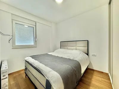 a bedroom with a large bed and a window at One bedroom Apartment 777 in Budva