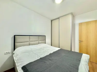 a bedroom with a large bed and a wooden door at One bedroom Apartment 777 in Budva