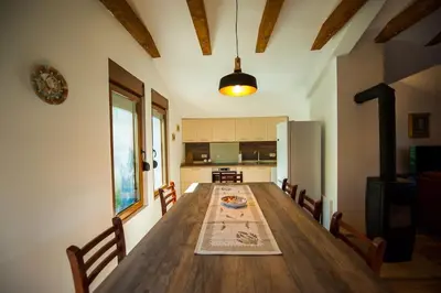 a kitchen with a long wooden table with chairs at Happy birds apartment in Virpazar
