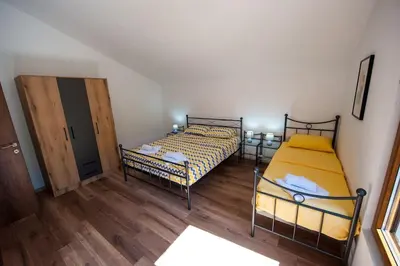 two beds in a room with wooden floors at Happy birds apartment in Virpazar