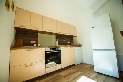 a kitchen with white cabinets and a white refrigerator at Happy birds apartment in Virpazar