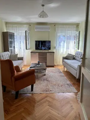 a living room with two couches and a tv at Apartman Bešović Cetinje in Cetinje