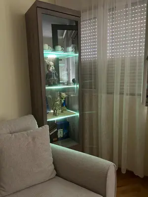 a living room with a cabinet and a couch at Apartman Bešović Cetinje in Cetinje