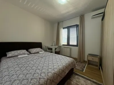 a bedroom with a bed and a table and a window at Apartments Martinovic Toplis in Budva