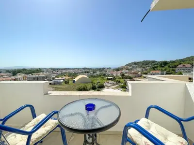 a table and chairs on a balcony with a view at Villa Grafenberg Ulcinj in Ulcinj
