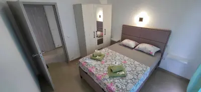 a bedroom with a bed with pillows and a mirror at Villa Grafenberg Ulcinj in Ulcinj