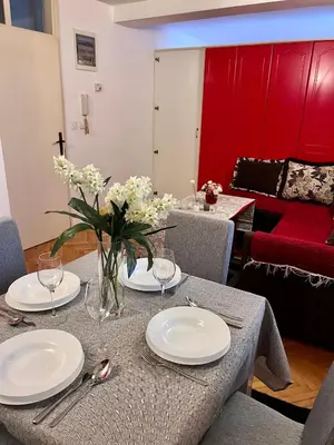 a table with white plates and flowers on it at Apartment Sofija in Kotor