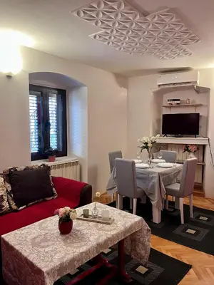 a living room with a red couch and a table at Apartment Sofija in Kotor
