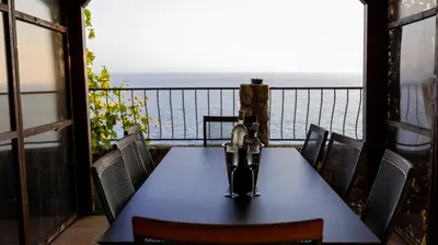 a table on a balcony with a view of the ocean at Sveti Luka private beach in Dobra Voda