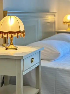 a table with a lamp on it next to a bed at Villa Sveti Stefan in Budva