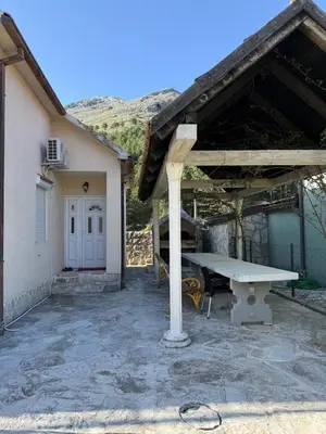 a picnic table in front of a house at Family house on the mountain - Krstac, Njegusi in Njeguši