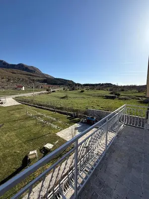 a balcony with a fence and a grass field at Family house on the mountain - Krstac, Njegusi in Njeguši