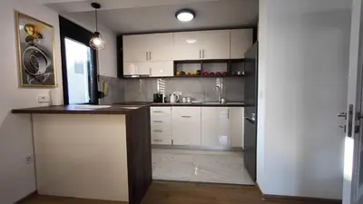 a kitchen with white cabinets and a counter top at Poolside Idyll in Bar