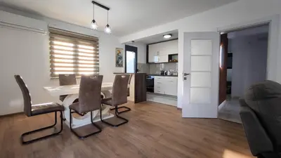 a kitchen and dining room with a table and chairs at Poolside Idyll in Bar