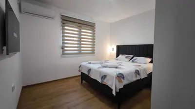 a bedroom with a bed and a window at Poolside Idyll in Bar