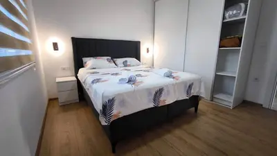 a bedroom with a bed with a white comforter at Poolside Idyll in Bar