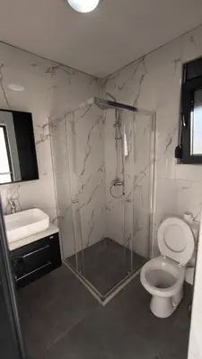 a bathroom with a shower and a toilet and a sink at Poolside Idyll in Bar