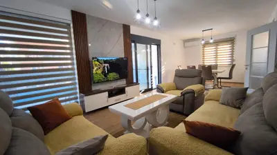 a living room with a couch and a tv at Poolside Idyll in Bar
