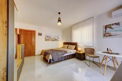 a bedroom with a bed and a table at Nike's Apartment in Dobra Voda