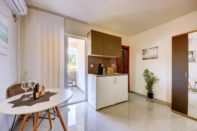 a kitchen with a white table and a white counter top at Nike's Apartment in Dobra Voda