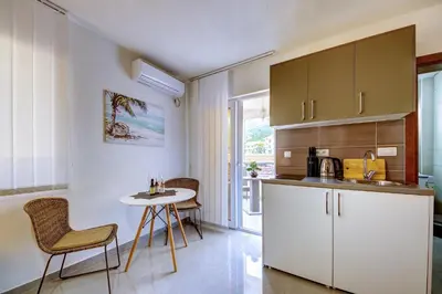 a kitchen with a table and chairs in a room at Nike's Apartment in Dobra Voda