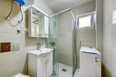 a bathroom with a shower and a toilet and a sink at Nike's Apartment in Dobra Voda