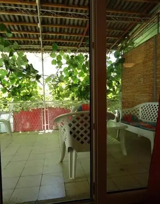 a glass door of a patio with a table and chairs at Iva Guest House in Sutomore