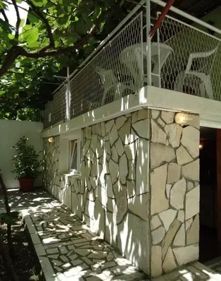 a balcony with a stone wall and a fence at Iva Guest House in Sutomore