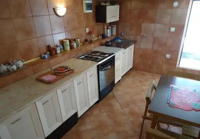 a kitchen with a stove and a table in it at Iva Guest House in Sutomore