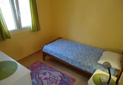 a small bedroom with a bed and a rug at Iva Guest House in Sutomore