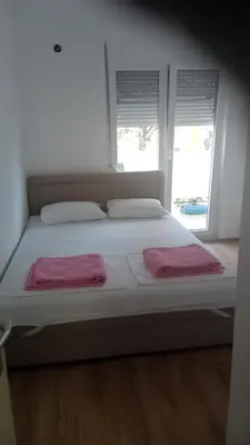 a white bed with two pink towels on top of it at Studio Dream I I in Bar, Susanj