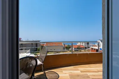 a balcony with a chair and a view of the ocean at Four Seasons Villa Valentina in Kotor