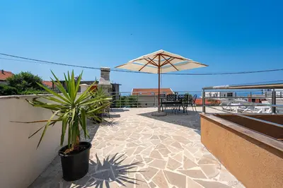 a patio with an umbrella and a table and chairs at Four Seasons Villa Valentina in Kotor