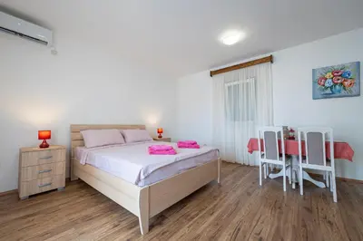 a bedroom with a bed and a table and chairs at Four Seasons Villa Valentina in Kotor