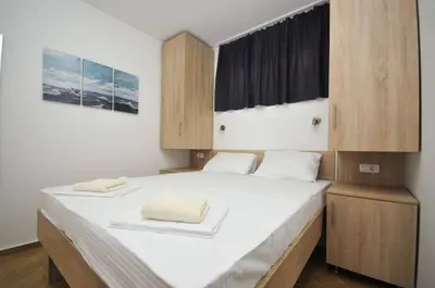 a bedroom with a bed with two towels on it at Apartments Jadranski Biser in Čanj