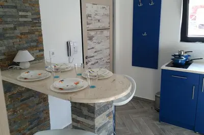 a kitchen with a marble counter with plates on it at Apartments Jadranski Biser in Čanj