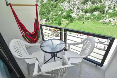 a balcony with chairs and a table and a hammock at Apartments Jadranski Biser in Čanj