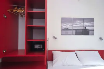a red book shelf next to a bed in a room at Apartments Jadranski Biser in Čanj